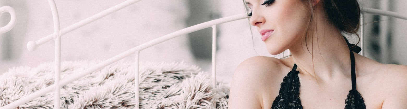 Frau sitzt vor einem weißen Bett