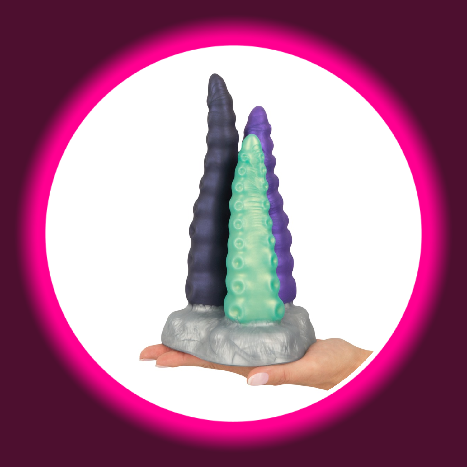 eine Hand hält einen silbernen Sockel mit drei Dildos in grün, violett und schwarz in Tentakel-Optik, Beasty Cocks Triple Tentacle