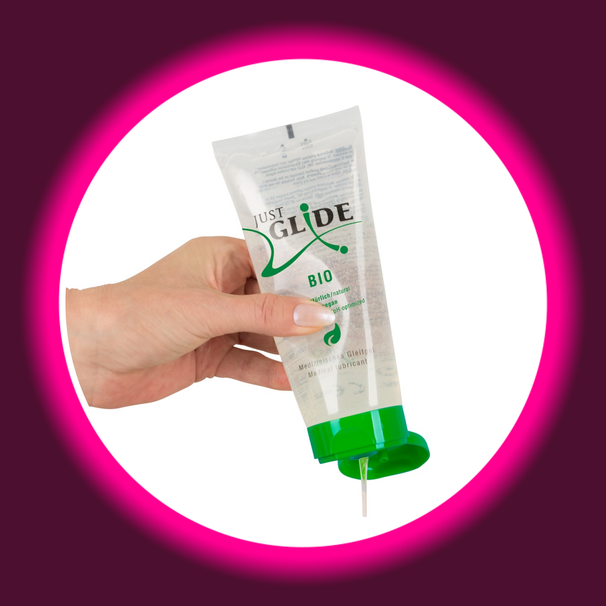 Just Glide Bio Gleitgel in der transparenten 200-ml-Tube, in einer Hand gehalten mit geöffnetem grünem Klappverschluss und austretendem Gel