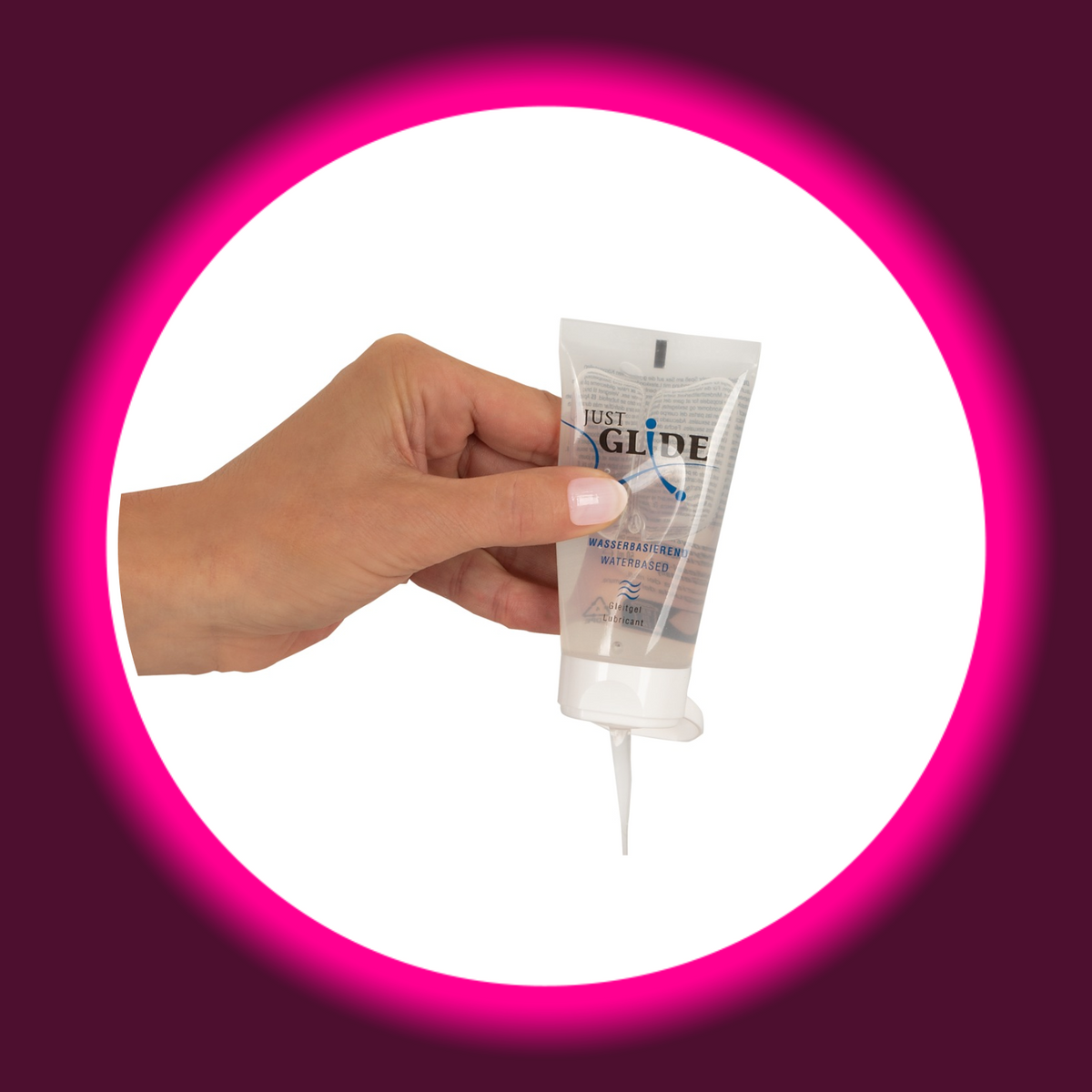 Just Glide wasserbasiertes Gleitgel in der transparenten 50-ml-Tube, in einer Hand gehalten mit geöffnetem Klappverschluss und austretendem Gel