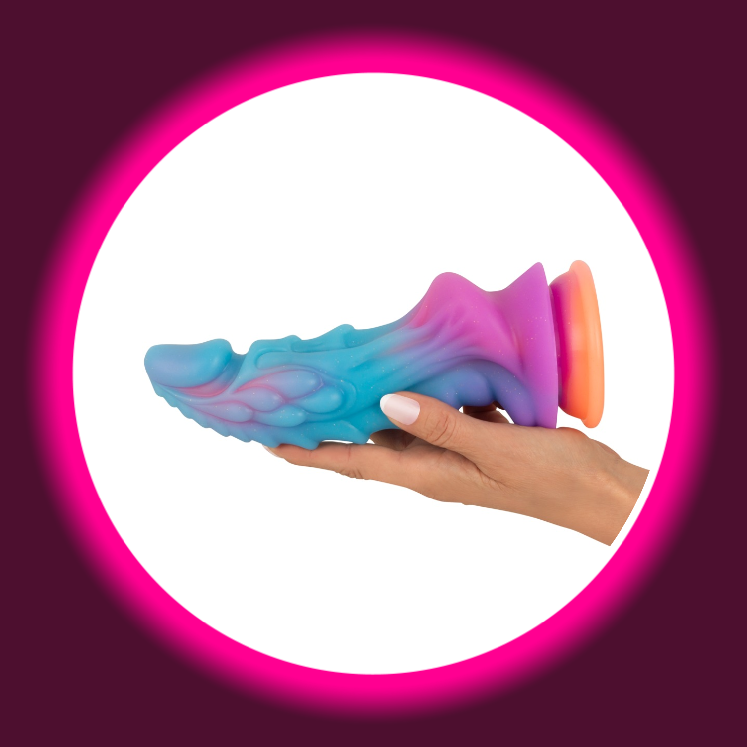 Mystic Dragon Dildo in schillernden Regenbogenfarben mit Drachenschuppen-Textur, handgehalten vor weissem Kreis - Beasty Cocks