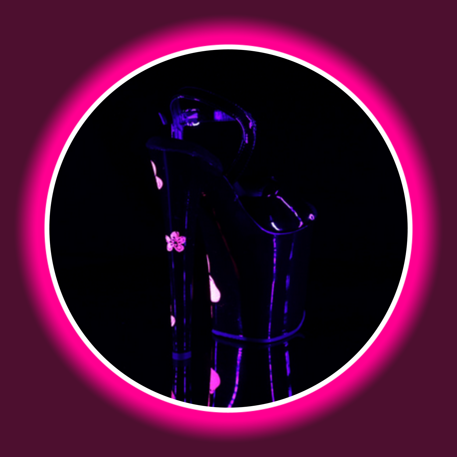 Winkelansicht uv-reaktive schwarze High Heels Pleaser Xtreme 809 mit pinken Hibiskus-Blüten und hohem Absatz vor schwarzem Hintergrund