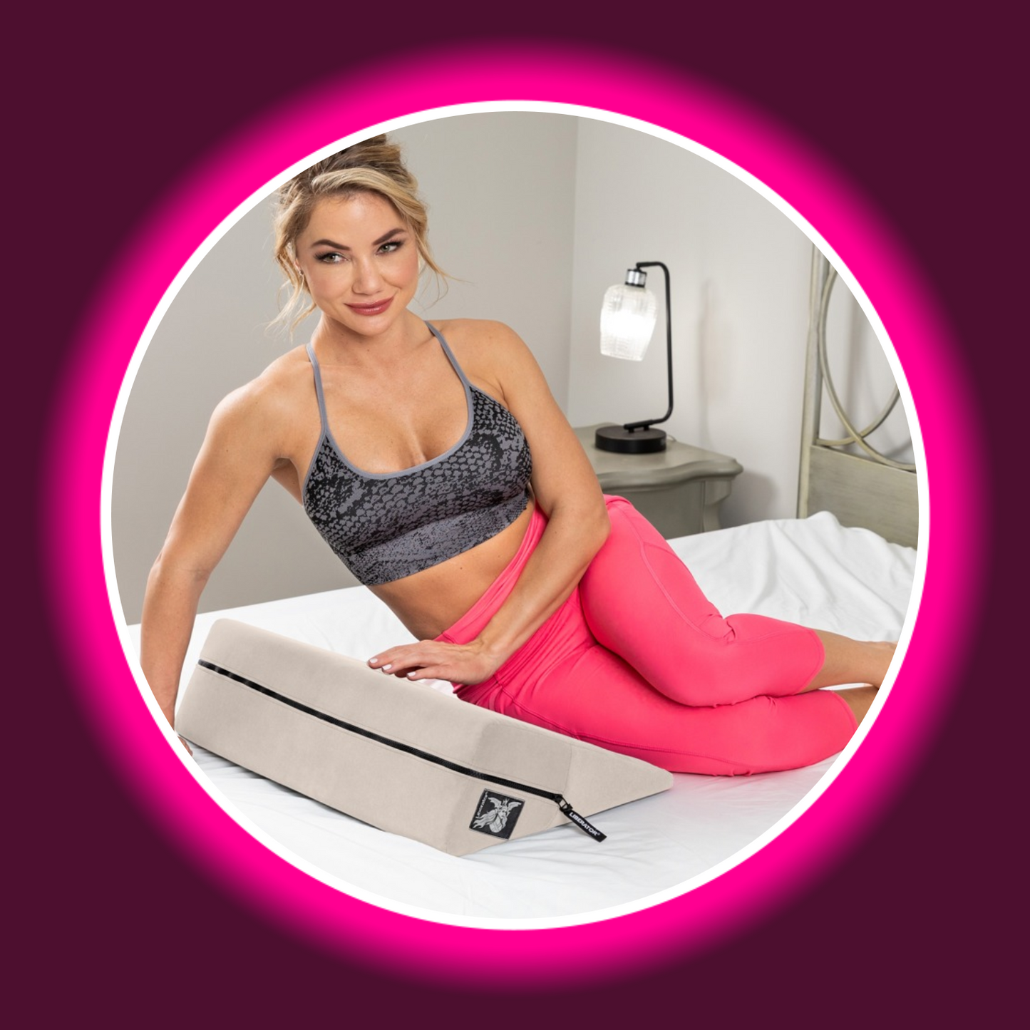 blonde Frau in sportlicher Bekleidung liegt seitlich auf einem Bett mit einem Keilkissen von Liberator, im Hintergrund eine Tischlampe