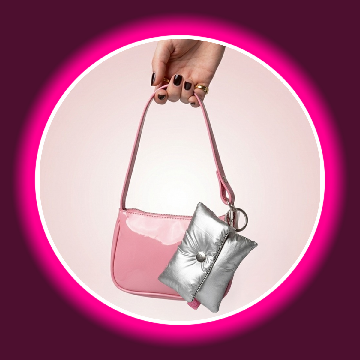 Womanizer Snap Accessory Pouch in Silber am Schlüsselring einer pinken Handtasche befestigt – kompakte Silber-Pouch als stylisches Taschenanhänger-Accessoire