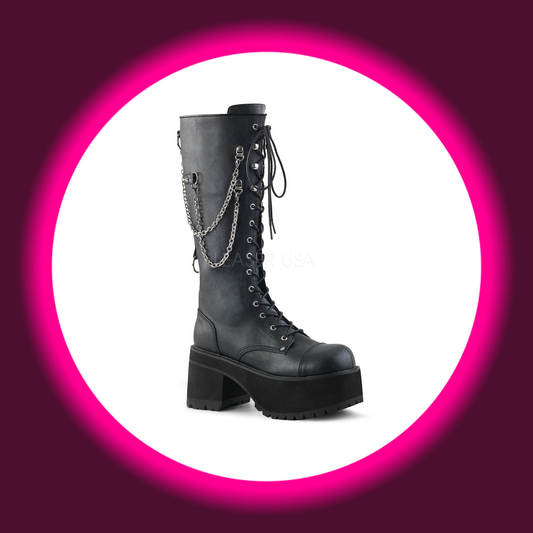 Winkelansicht auf schwarze Stiefel mit dicker Sohle, Plateau, Frontschnürung und Zierketten auf weißem Untergrund