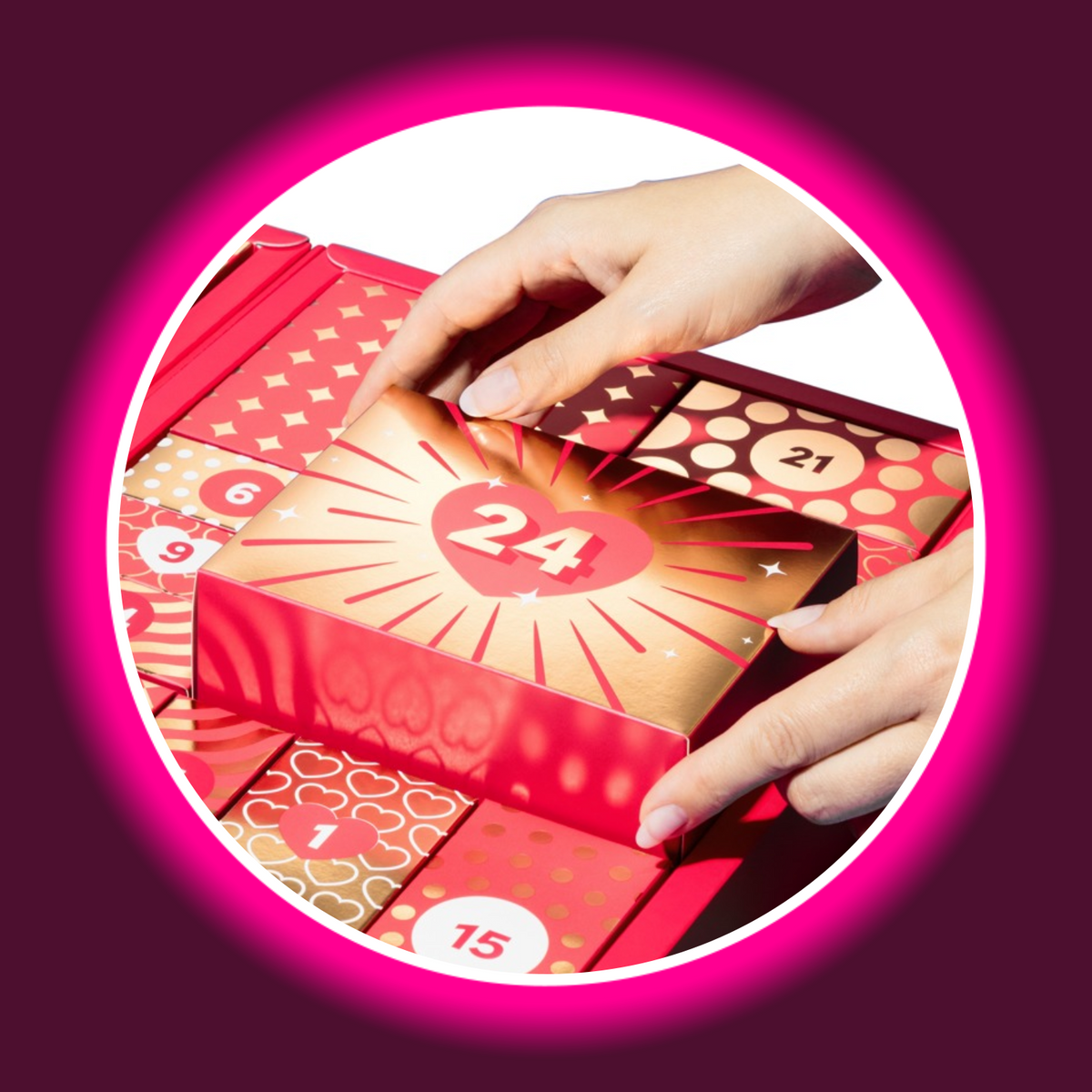 Magic Shiver Couples Erotik-Adventskalender 2026, Hände entnehmen die rot-goldfarbene Geschenkbox Nummer 24 mit Herz- und Strahlenmotiv