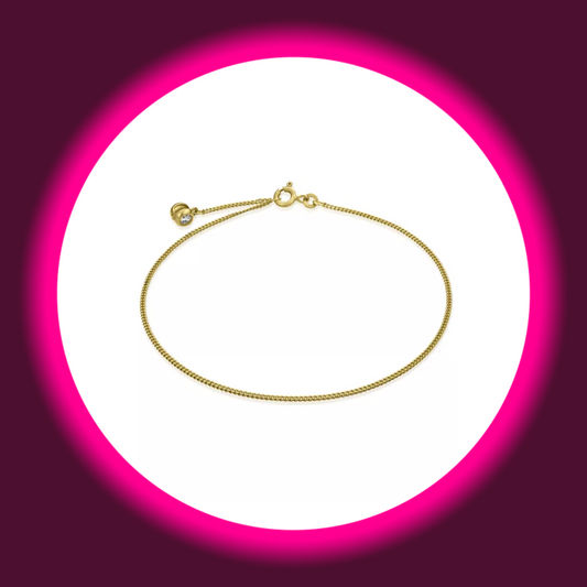 Draufsicht auf eine goldene schmale Fußkette mit Zierstein von Modabilé auf weißem Untergrund