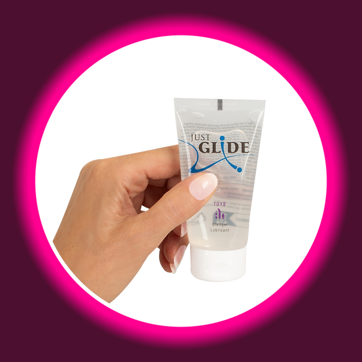 Just Glide Toys Gleitgel in der transparenten 50-ml-Tube mit weißem Verschluss und violettem Toy-Motiv, Frontansicht in einer Hand gehalten