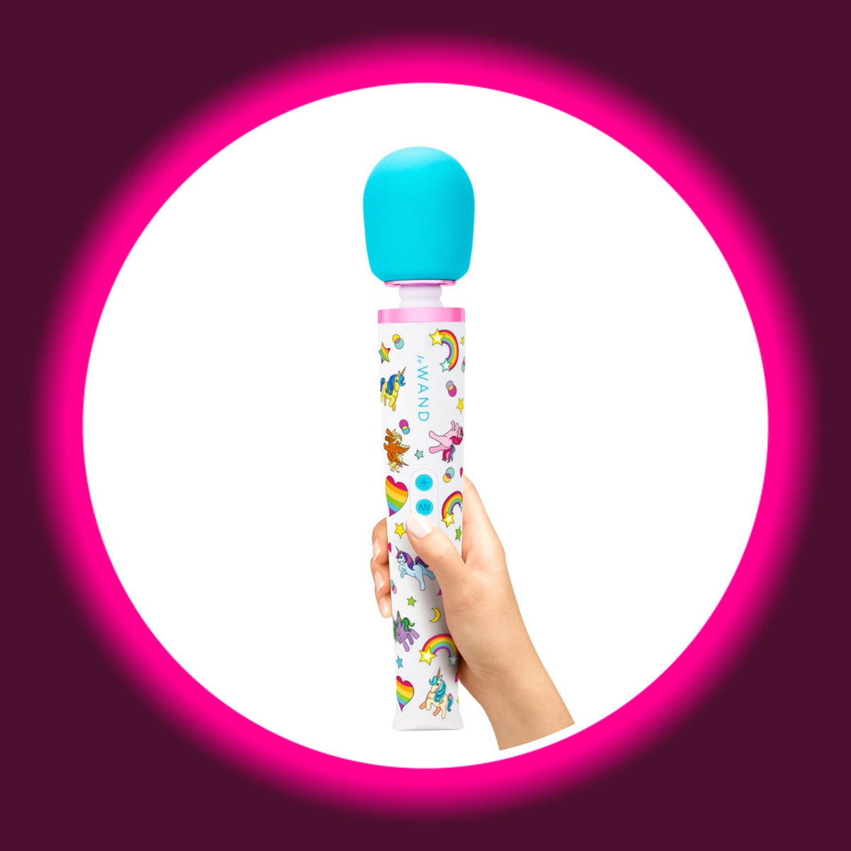 le WAND Unicorn Wand Massagestab in der Hand gehalten – Größenvergleich, weißer Griff mit buntem Einhorn- und Regenbogen-Print, türkisfarbener Soft-Touch-Massagekopf