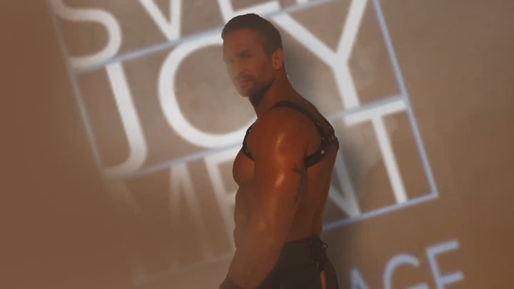 Mann präsentiert den Gladiator Rock mit Brustharness und Handfesseln von Svenjoyment Bondage