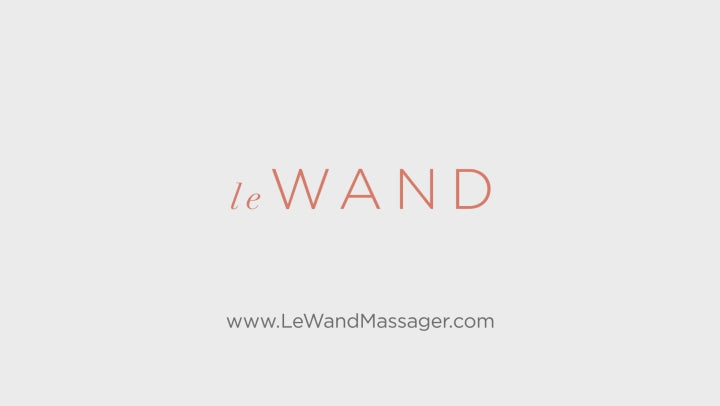 eine Frau präsentiert den Massagestab von Le Wand