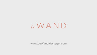 eine Frau präsentiert den Massagestab von Le Wand