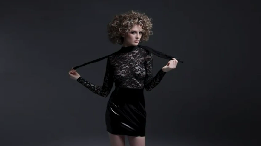 Frau in schwarzem Minikleid tanzt vor schwarzem Hintergrund - BLACK LEVEL
