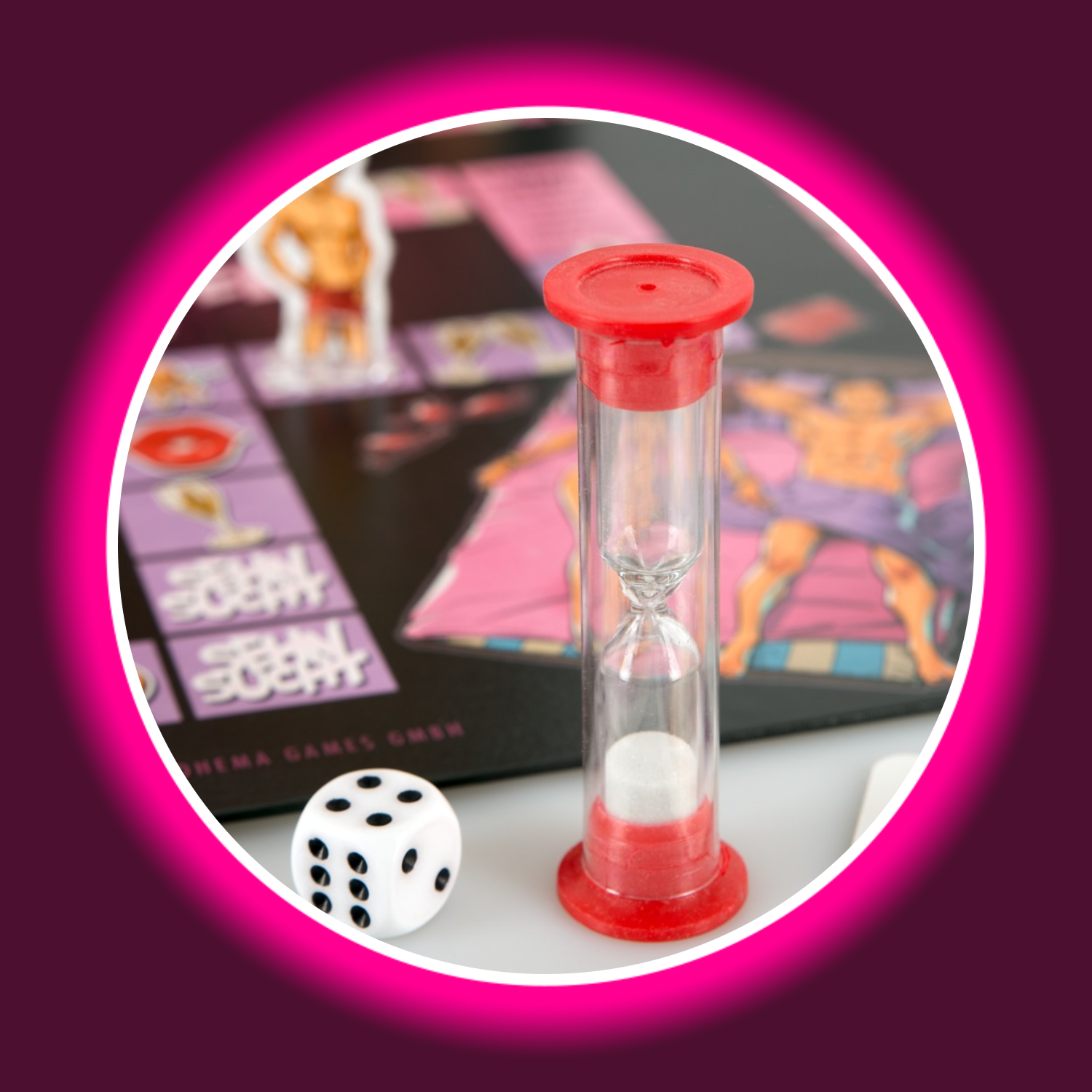 ein Würfel und eine Sanduhr stehen vor dem bunten Spielfeld des Brettspiels Schmuseduell