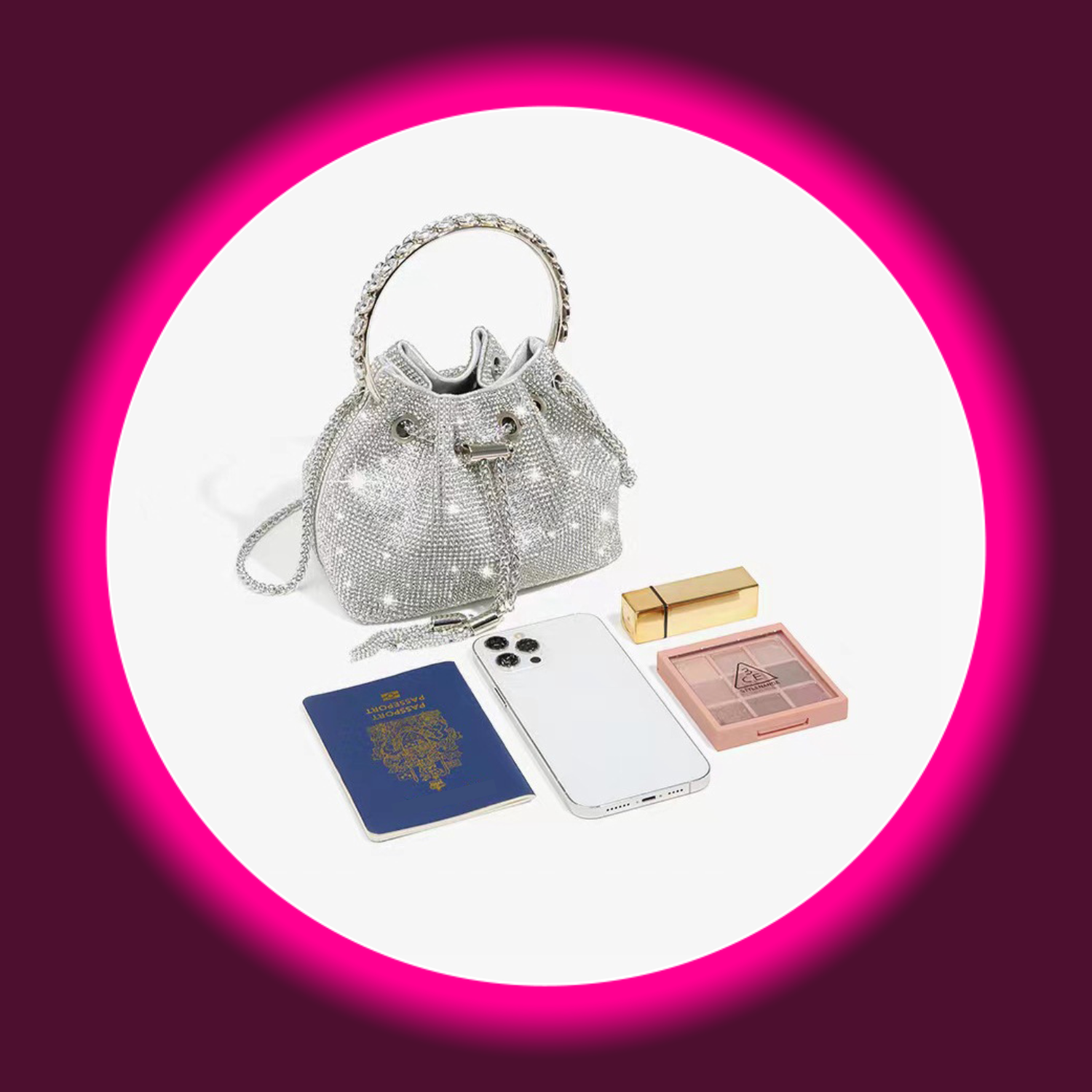 silberne kleine Handtasche mit rundem Tragegriff und Kordelzug, komplett mit Straßsteinen besetzt, davor liegend ein Reisepass, Smartphone und Schminksachen
