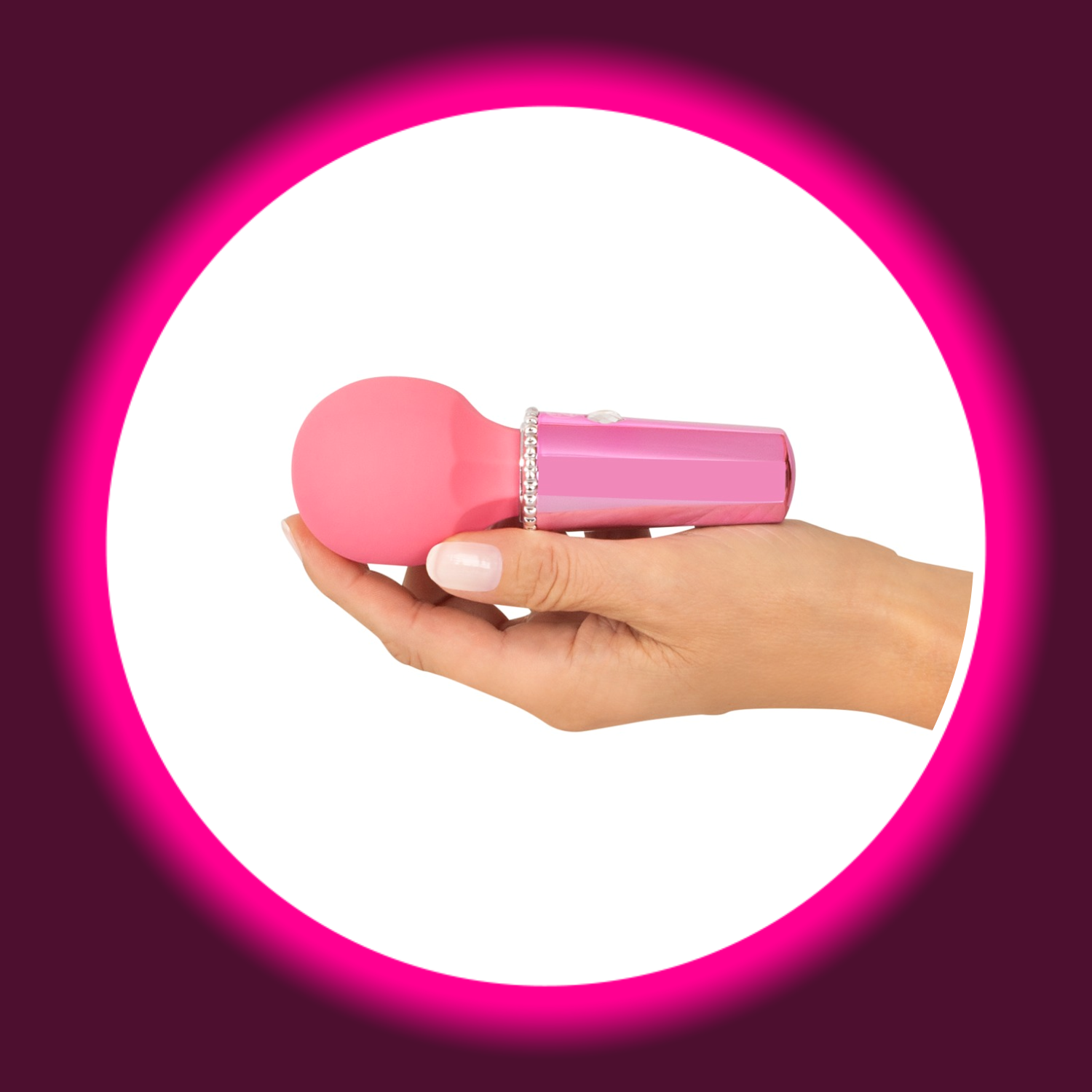 eine Hand hält einen kleinen pinken Wandvibrator mit Glitzersteinen von You2Toys